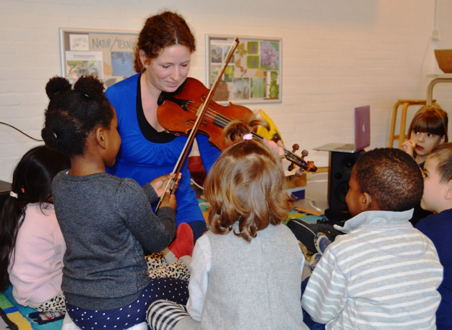 Når Gabriella Meinert-Medici laver workshops på daginstitutionerne, har hun blandt andet en stor violin og små børnevioliner med. Foto: Genklange