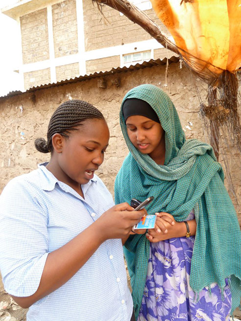 En af projektets kenyanske samarbejdspartnere hjælper en somalisk flygtning med at registrere sig via mobiltelefonen. Foto: Refugees United