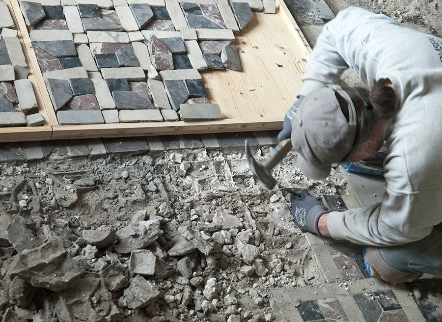 Gulvet var sunket, og flere af de små mosaiksten lå løse eller var knækkede. Her tages stykkerne op og lægges i trækasser, så de beholder deres oprindelige pladser. Foto: Rosenborg Slot