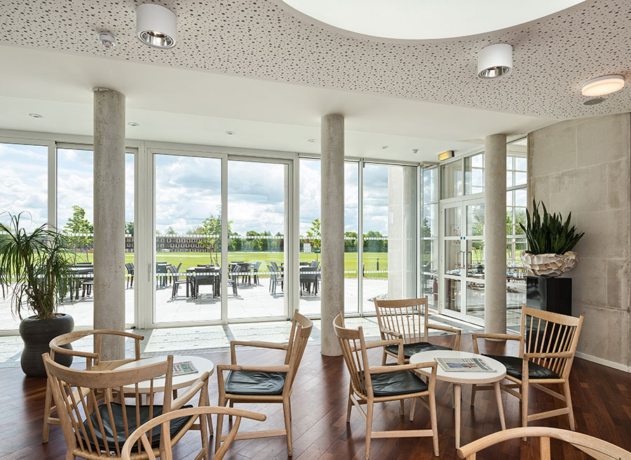 En omfattende udvidelse har bl.a. givet The Møller Centre en ny lounge med Wegner-stole og udsigt til Churchill Colleges plæne. Foto: Andrew Hatfield